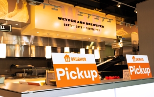 Weyden + Brewster sign in the background and a Grubhub Pick up sign