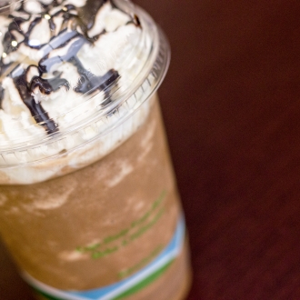 Cold coffee beverage with whipped cream and chocolate drizzle