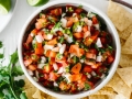Pico de Gallo in a bowl with chips on the side