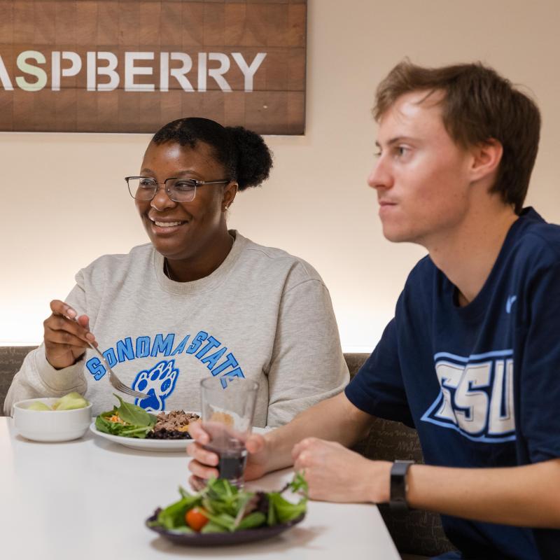 two students eating at the kitchens
