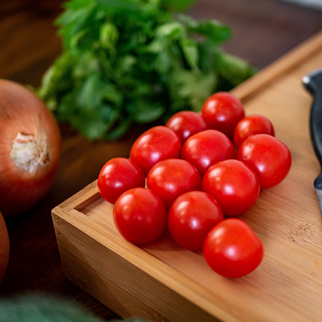Tomatoes, onion and basil on a wood cutting board