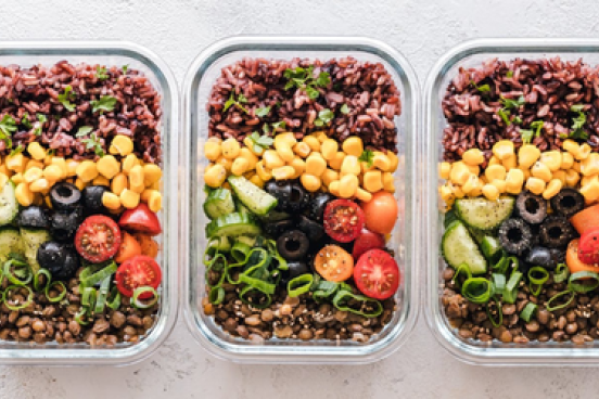 Meal in a container with corn, olives, tomatoes, ground beef