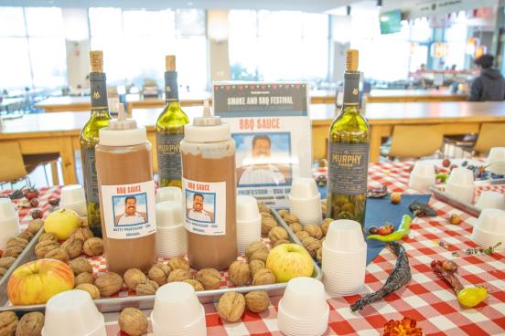 bbq sauce bottles on a red and white table cloth