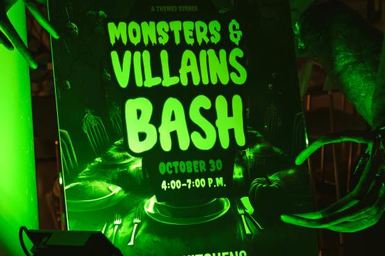 monsters and villains bash sign lit by green light