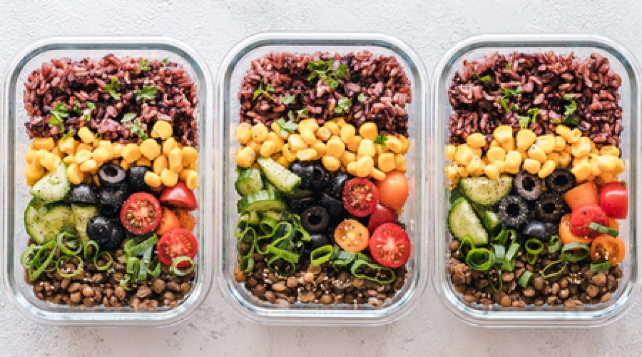 Meal in a container with corn, olives, tomatoes, ground beef