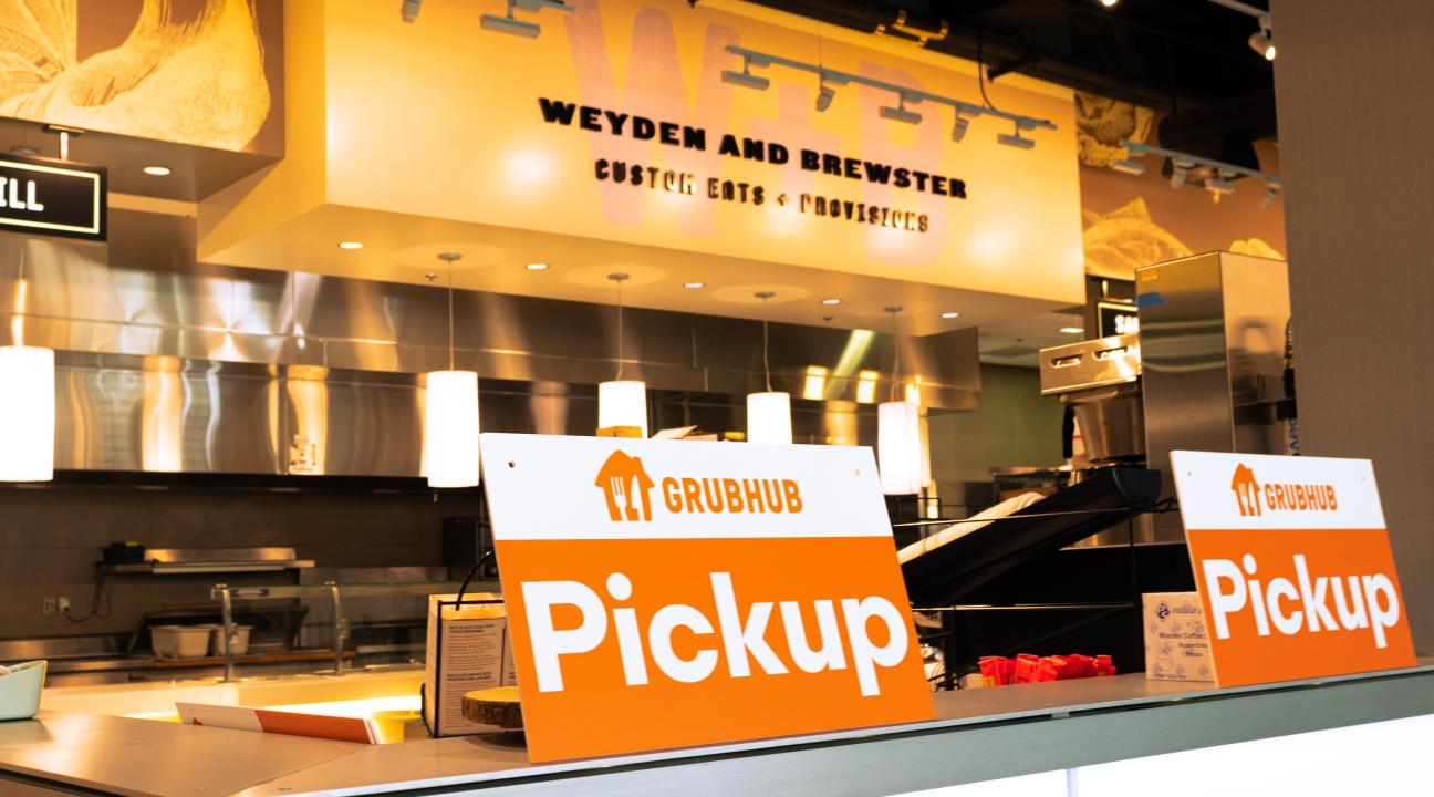 Weyden + Brewster sign in the background and a Grubhub Pick up sign
