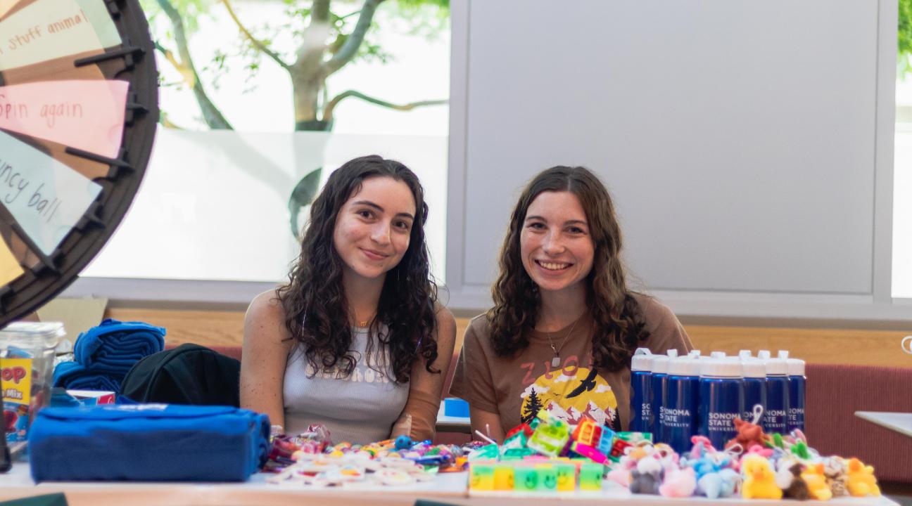 Two students sitting the prize wheel