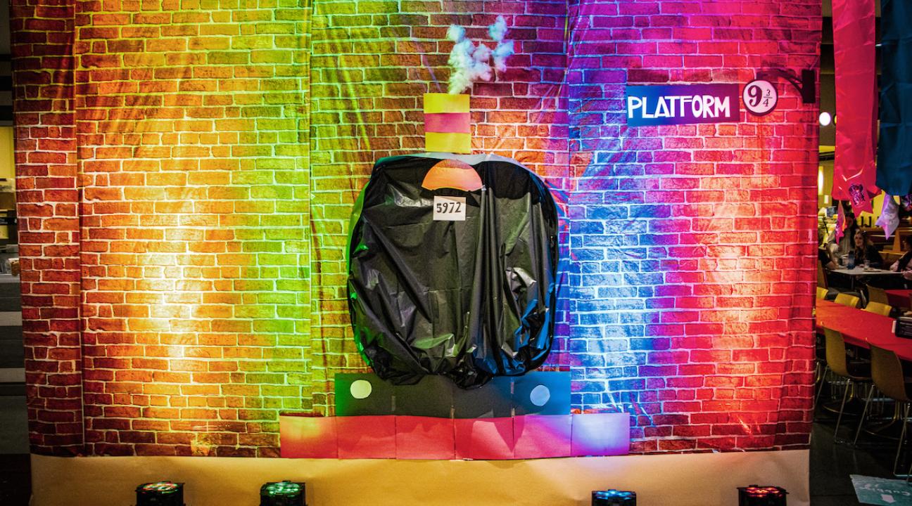 a brick wall with a train design and a sign saying Platform 9 3/4