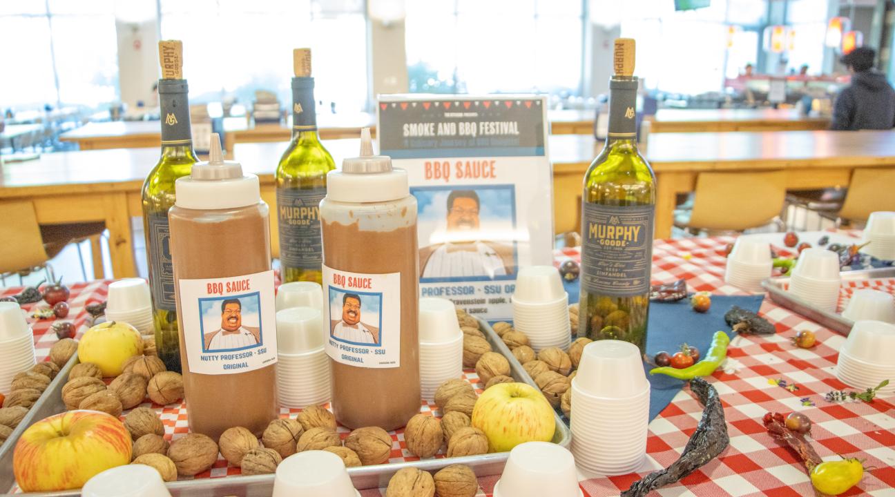 bbq sauce bottles on a red and white table cloth