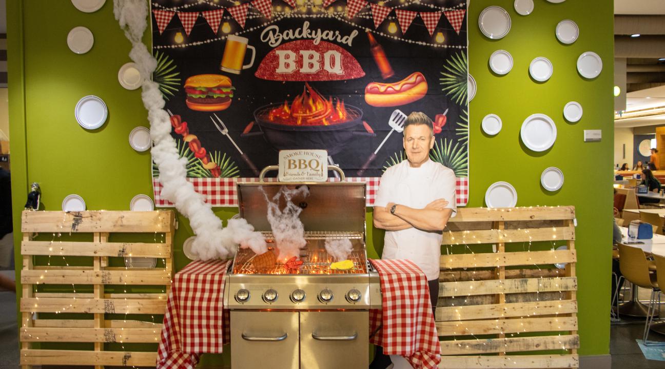 a grill with a gordon ramsay cutout next to it. 