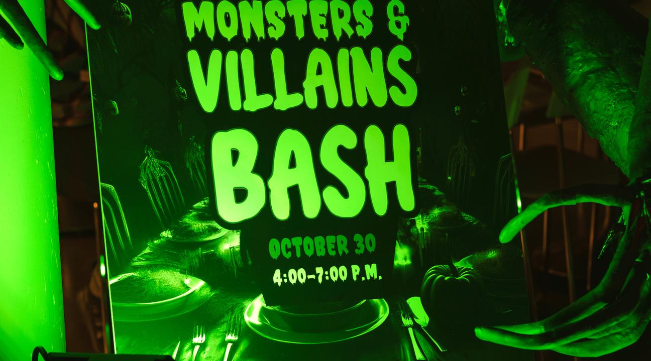 monsters and villains bash sign lit by green light