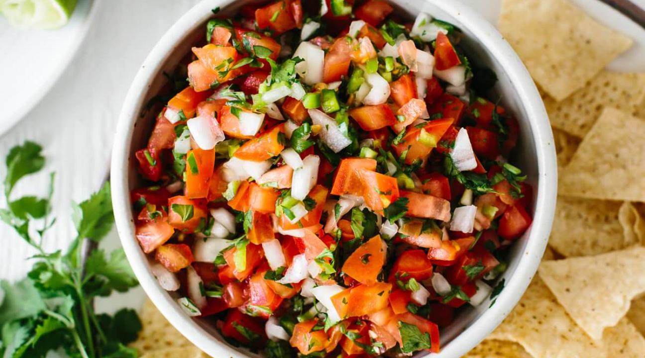Pico de Gallo in a bowl with chips on the side