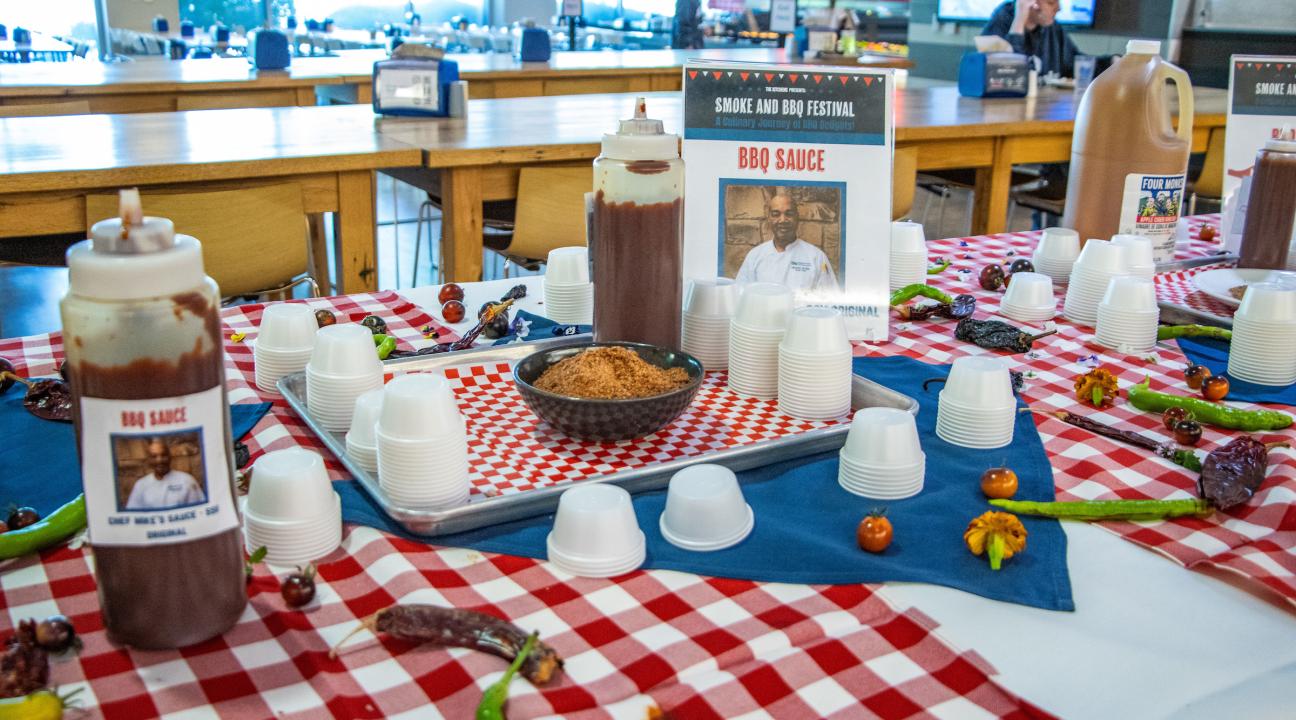 bbq sauce bottles on a red and white table cloth