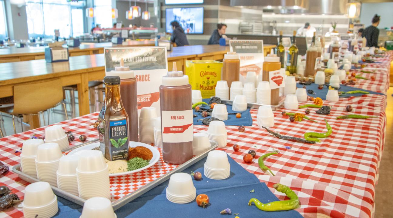 bbq sauce bottles on a red and white table cloth