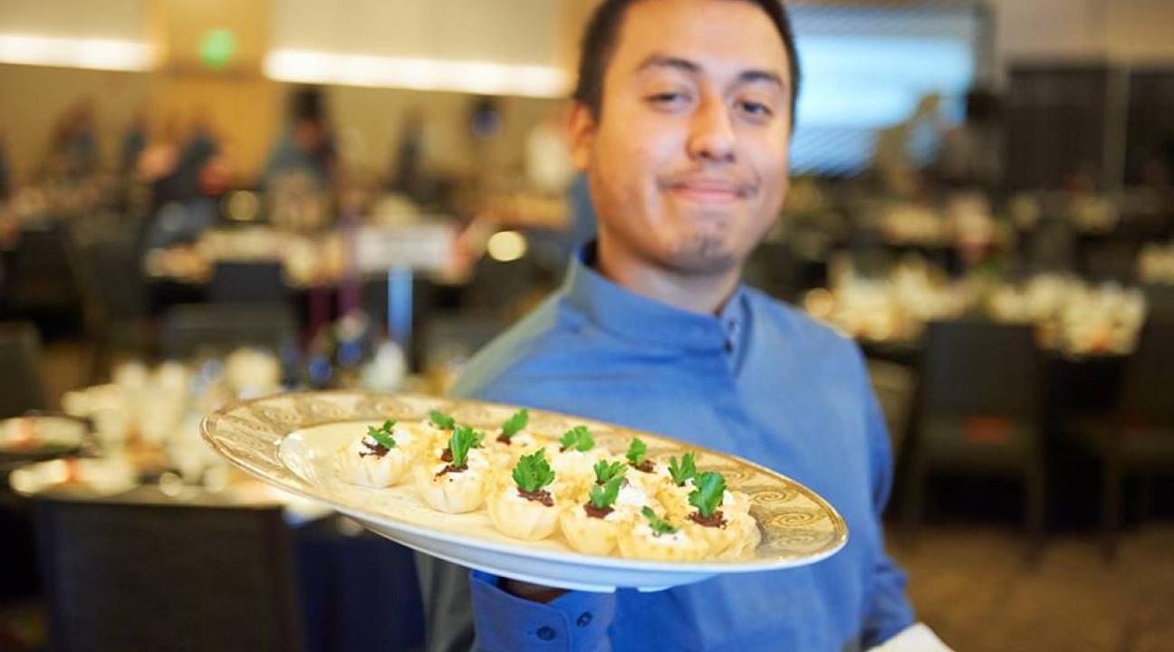 Student employee holding food plate 