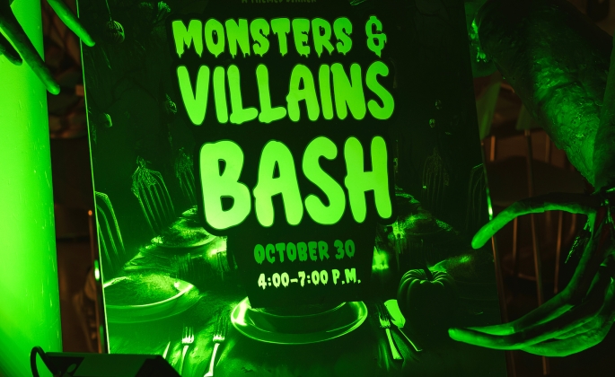 monsters and villains bash sign lit by green light