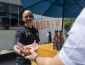Employee smiling and handing a burger on a tray to a customer 