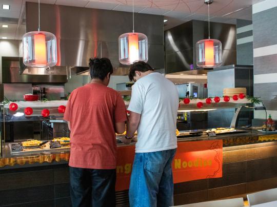 two students getting food at event