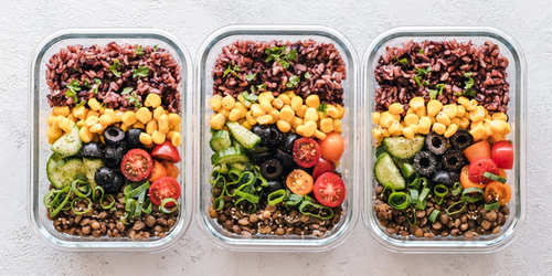 Meal in a container with corn, olives, tomatoes, ground beef