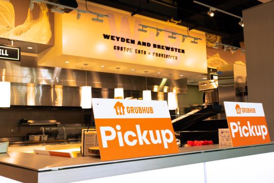 Weyden + Brewster sign in the background and a Grubhub Pick up sign