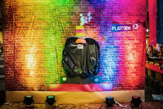 a brick wall with a train design and a sign saying Platform 9 3/4