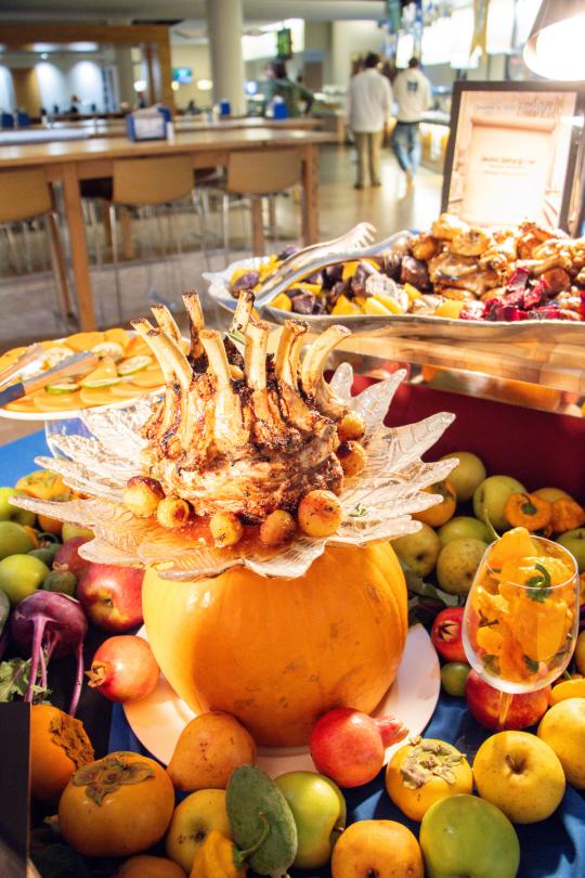 a table with decorated pumpkins and dinner dishes