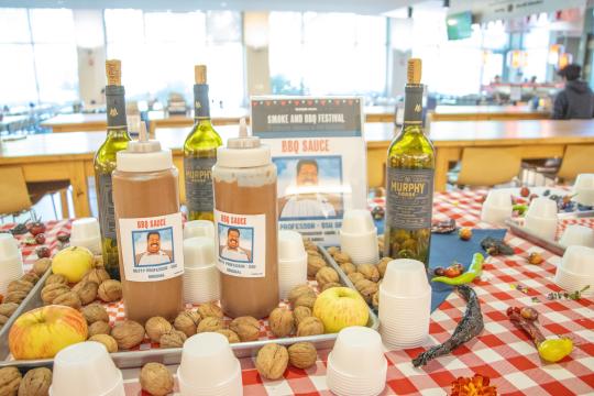 bbq sauce bottles on a red and white table cloth