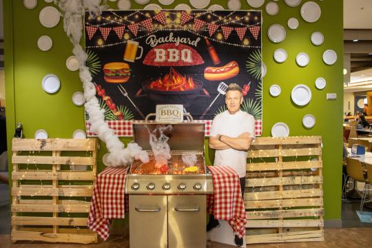 a grill with a gordon ramsay cutout next to it. 