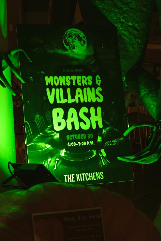 monsters and villains bash sign lit by green light