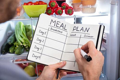 Meal plan journal notebook in someones hands