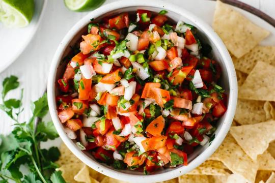 Pico de Gallo in a bowl with chips on the side