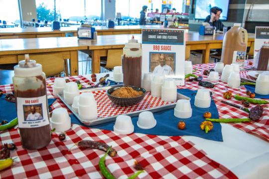 bbq sauce bottles on a red and white table cloth