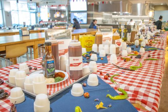 bbq sauce bottles on a red and white table cloth