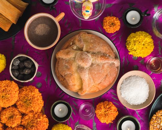 a table with a purple cloth and pan de muerto