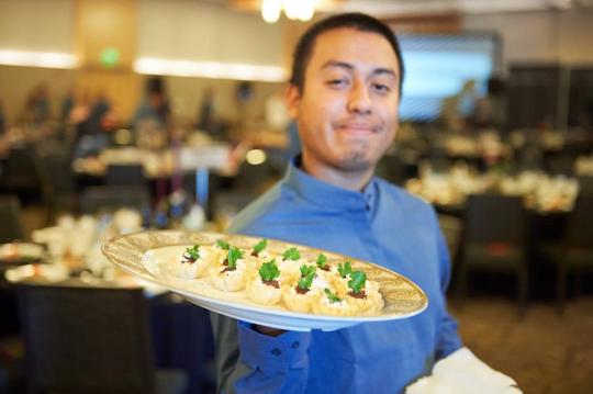 Student employee holding food plate 